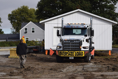 Lieutenant Governor Cournoyer inside the IPI truck as the house is delivered to the destination lot